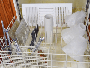 Apartments For Rent in Katy TX, Oak Park Apartments A dishwasher in Oak Park Apartments with a basket full of cleaning supplies.