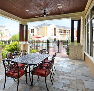 Apartments For Rent in Katy TX, Oak Park Apartments The Oak Park Apartments offers a cozy covered patio with a table and chairs, perfect for relaxing outdoors.